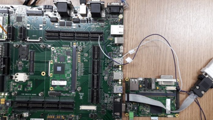 Vista de cima da Apalis Evaluation Board (à esquerda) e Iris Carrier Board (à direita) lado a lado, já conectadas pelos fios branco e roxo.